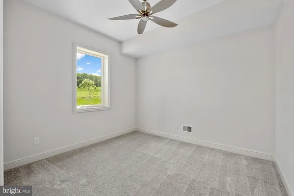 an empty room with a window and a fan