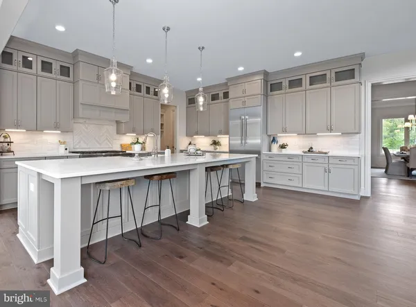 a large kitchen with kitchen island a sink stainless steel appliances and cabinets