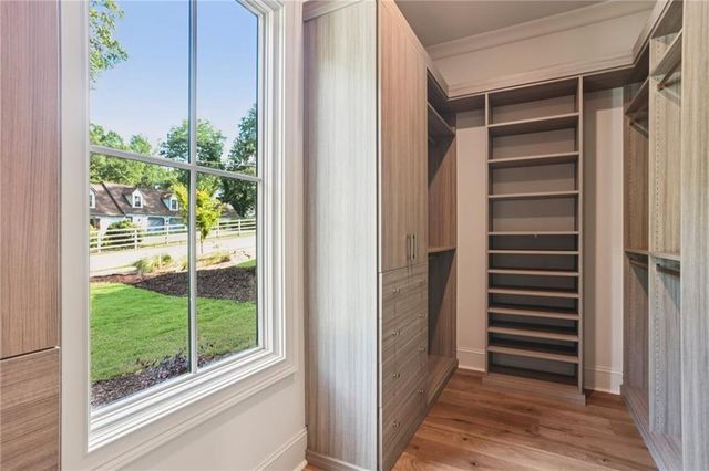 a view of empty room with wooden floor and windows