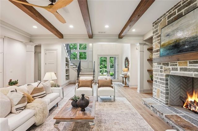 a living room with furniture a fireplace and a floor to ceiling window