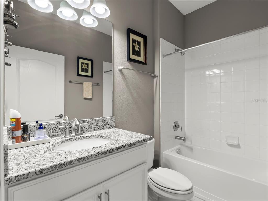 15433 Porter Road Winter Garden, FL 34787 - Photo 18 of 46 a bathroom with a granite countertop sink a toilet and shower
