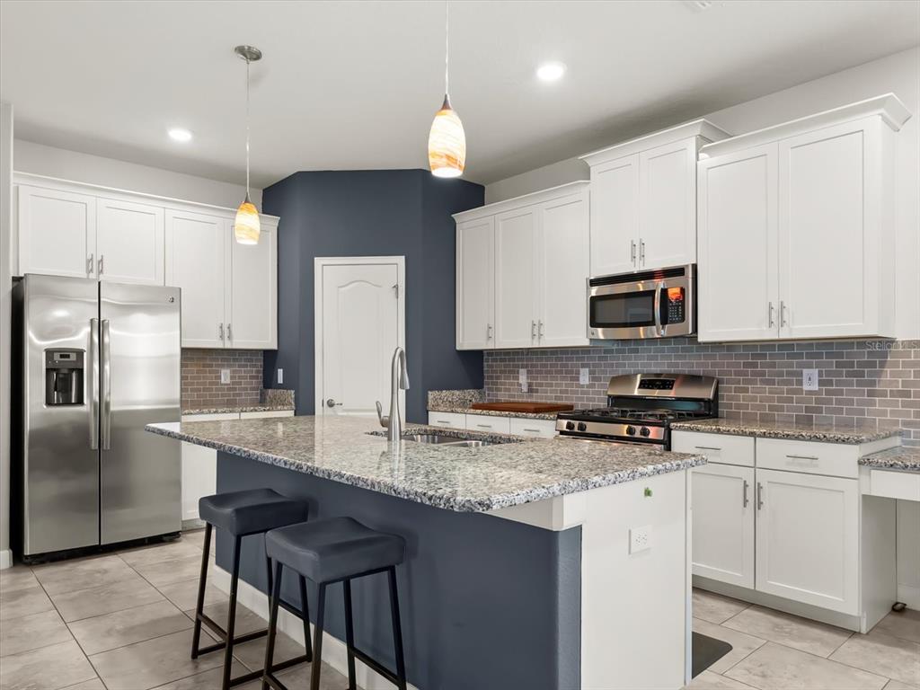 15433 Porter Road Winter Garden, FL 34787 - Photo 20 of 46 a kitchen with kitchen island granite countertop a stove sink and microwave