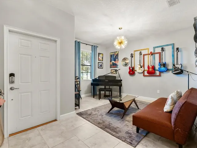a living room with furniture a dining table and a chandelier