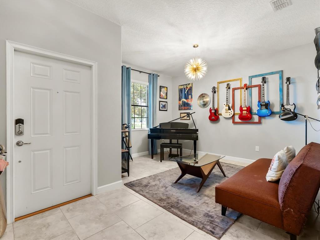 15433 Porter Road Winter Garden, FL 34787 - Photo 10 of 46 a living room with furniture a dining table and a chandelier