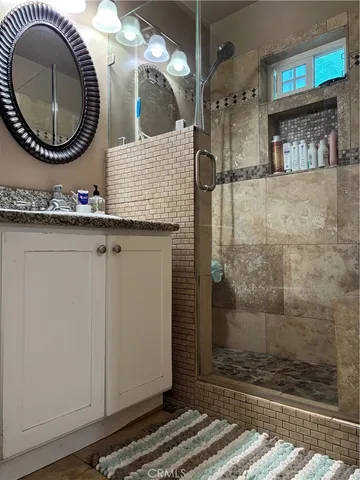 a bathroom with a sink a mirror and a shower