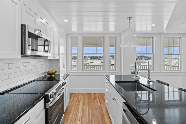 a kitchen with granite countertop a stove a sink and a refrigerator