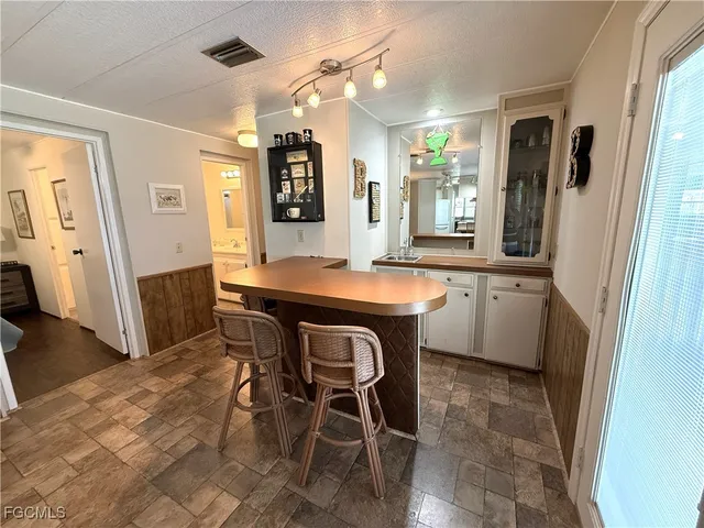 a kitchen with a table chairs sink refrigerator and microwave