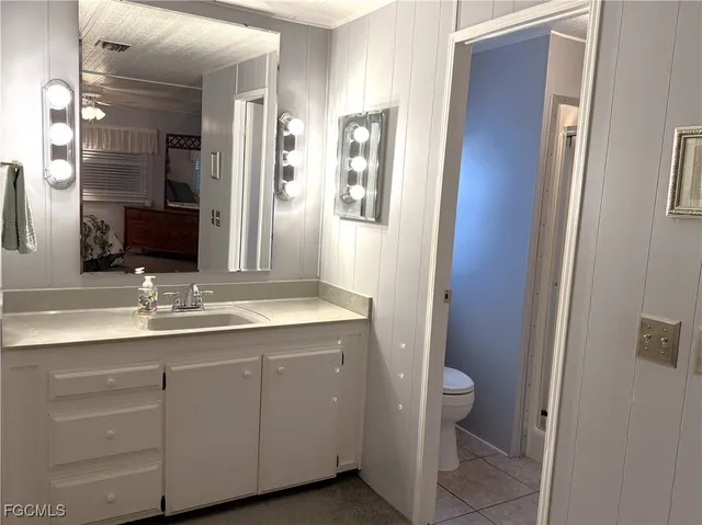 a bathroom with a double vanity sink toilet and mirror