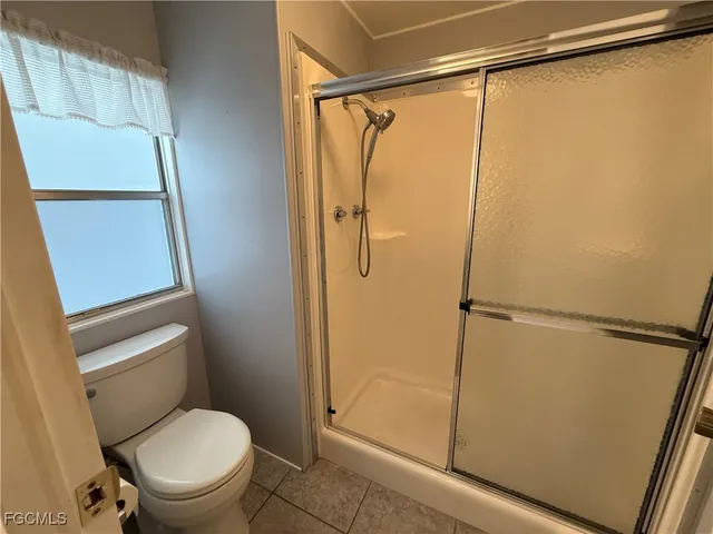 a white toilet sitting next to a shower
