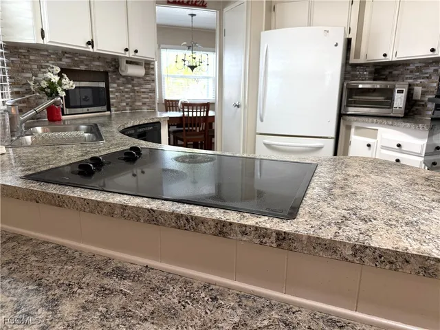 a kitchen with granite countertop a refrigerator and a sink