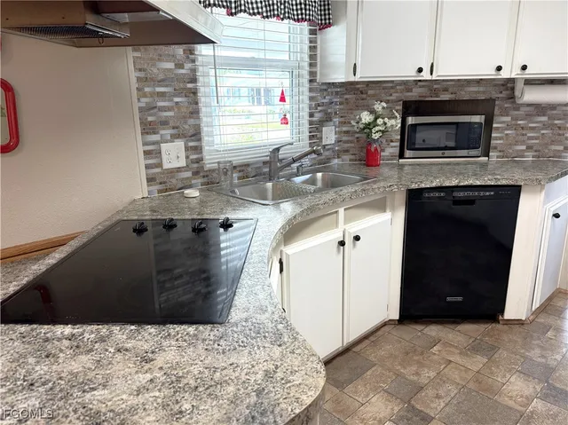 a kitchen with stainless steel appliances kitchen island granite countertop a stove a sink and a microwave