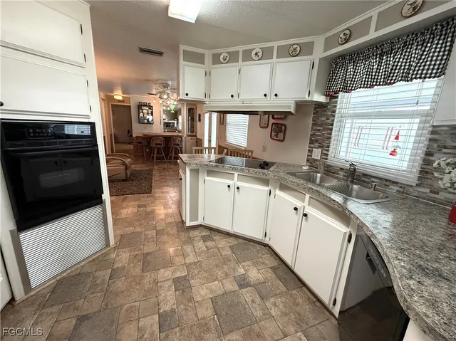 a kitchen with stainless steel appliances granite countertop a sink stove and cabinets