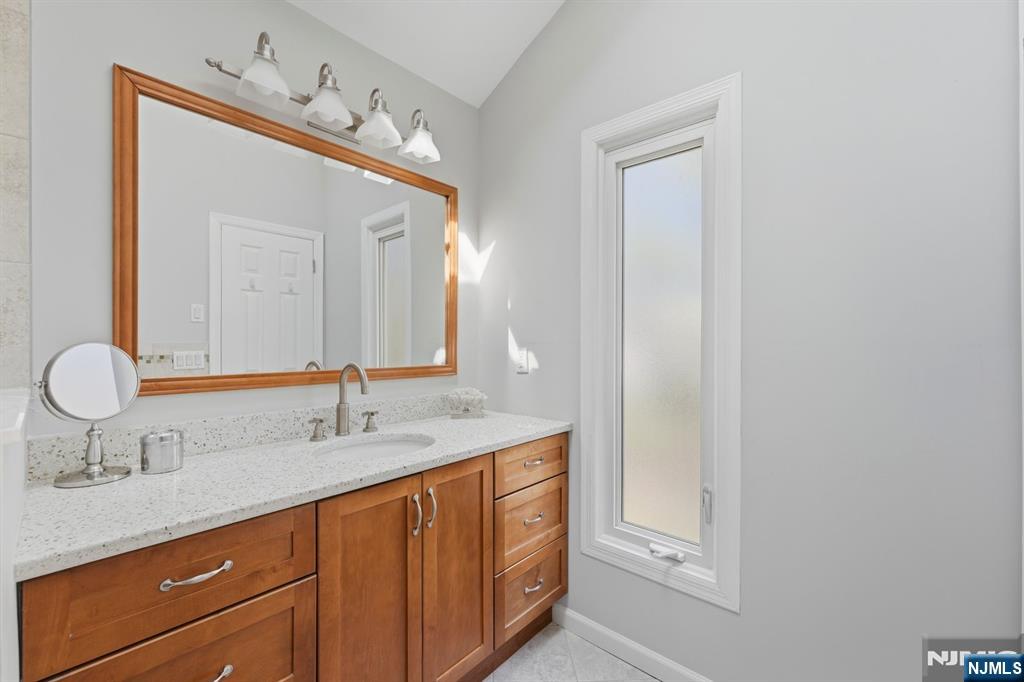89 Surrey Lane Tenafly, NJ 07670 - Photo 32 of 49 a bathroom with a double vanity sink and a mirror
