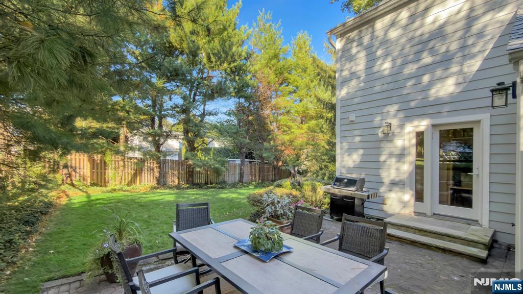 89 Surrey Lane Tenafly, NJ 07670 - Photo 44 of 49 a view of a backyard with couches table and chairs and potted plants