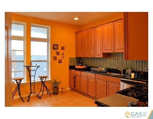 358 Rector Street, Unit STREET 703 Perth Amboy, NJ 08861 - Photo 4 of 10 a kitchen with stainless steel appliances a sink counter top space and a window