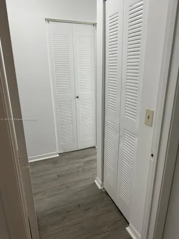 an empty room with wooden floor and chandelier fan