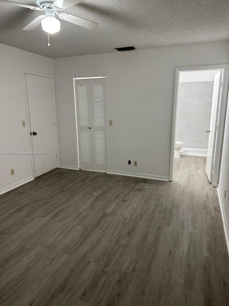 2259 Linton Ridge Circle, Unit G4 Delray Beach, FL 33444 - Photo 14 of 25 an empty room with wooden floor and chandelier fan