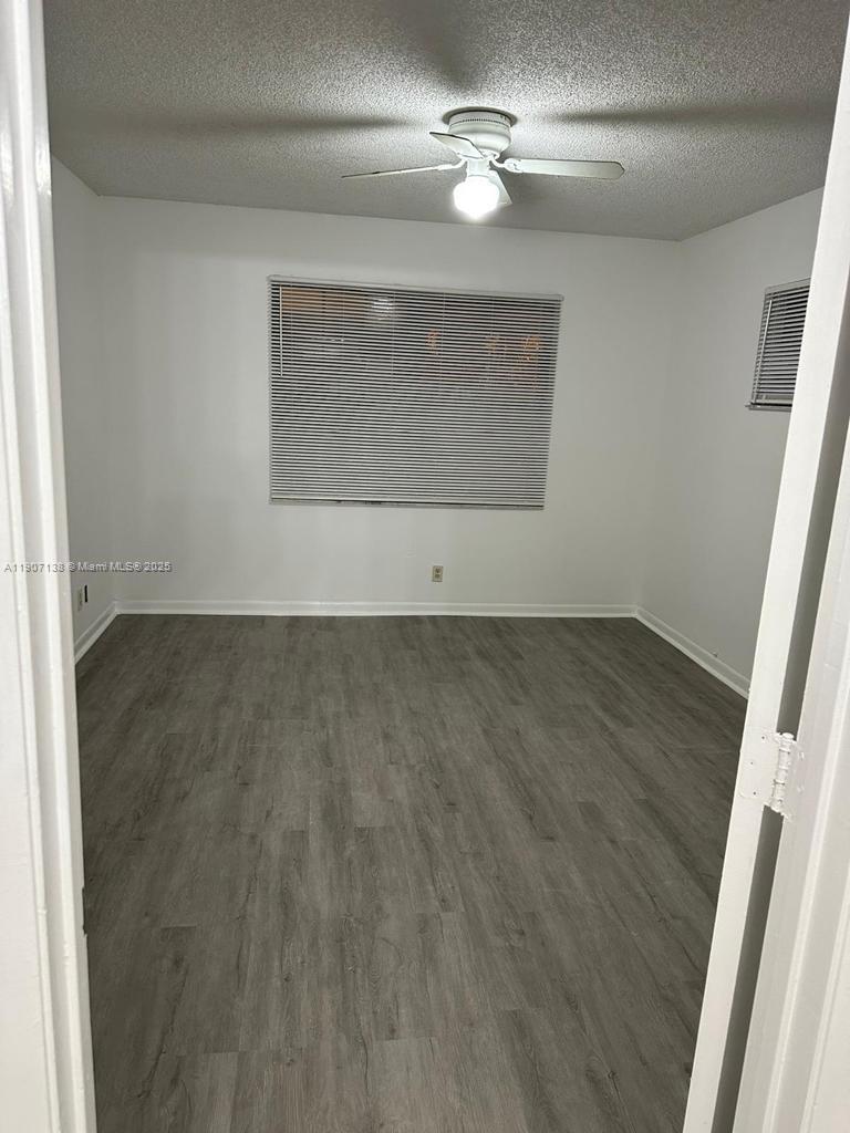 2259 Linton Ridge Circle, Unit G4 Delray Beach, FL 33444 - Photo 18 of 25 an empty room with wooden floor fan and windows