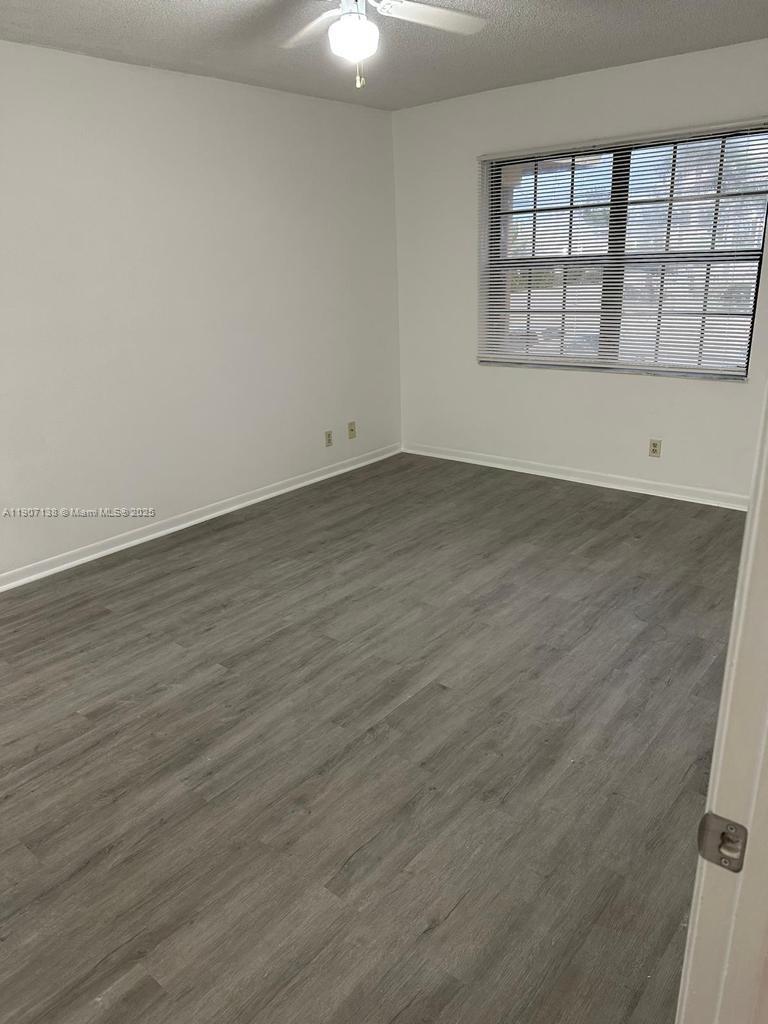 2259 Linton Ridge Circle, Unit G4 Delray Beach, FL 33444 - Photo 25 of 25 an empty room with wooden floor and windows
