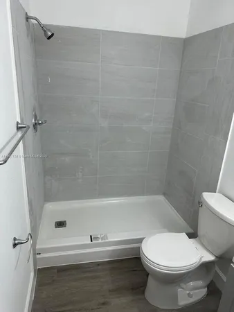 a spacious bathroom with a toilet a sink and mirror
