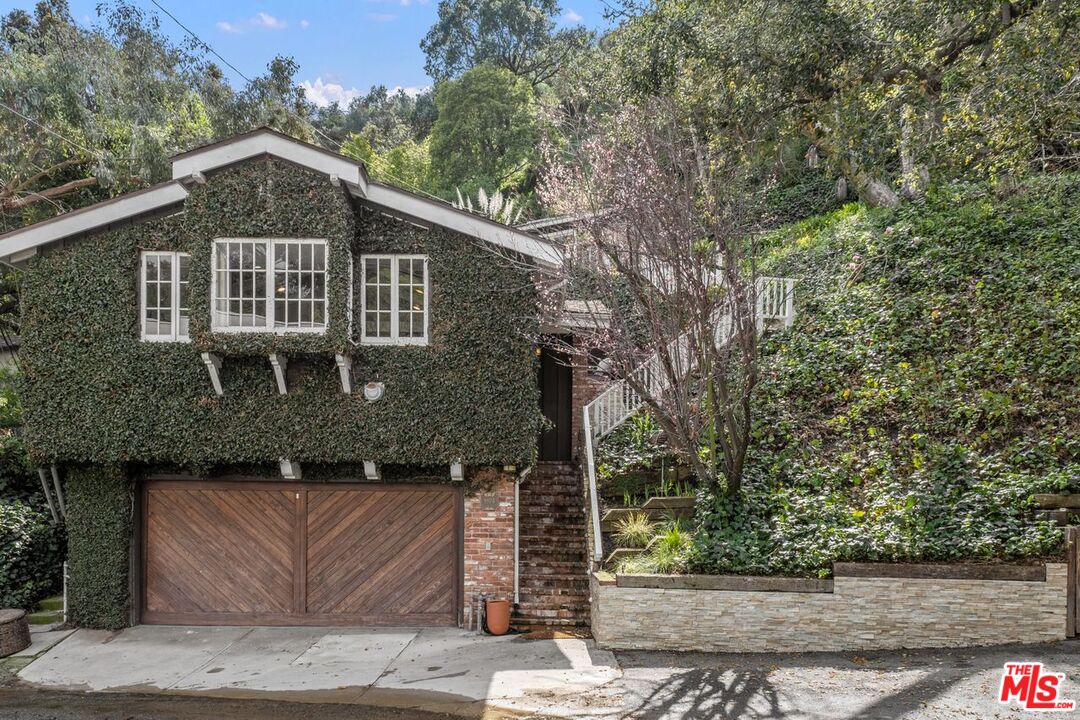 9934 Westwanda Drive Beverly Hills, CA 90210 - Photo 1 of 29 a front view of a house with trees