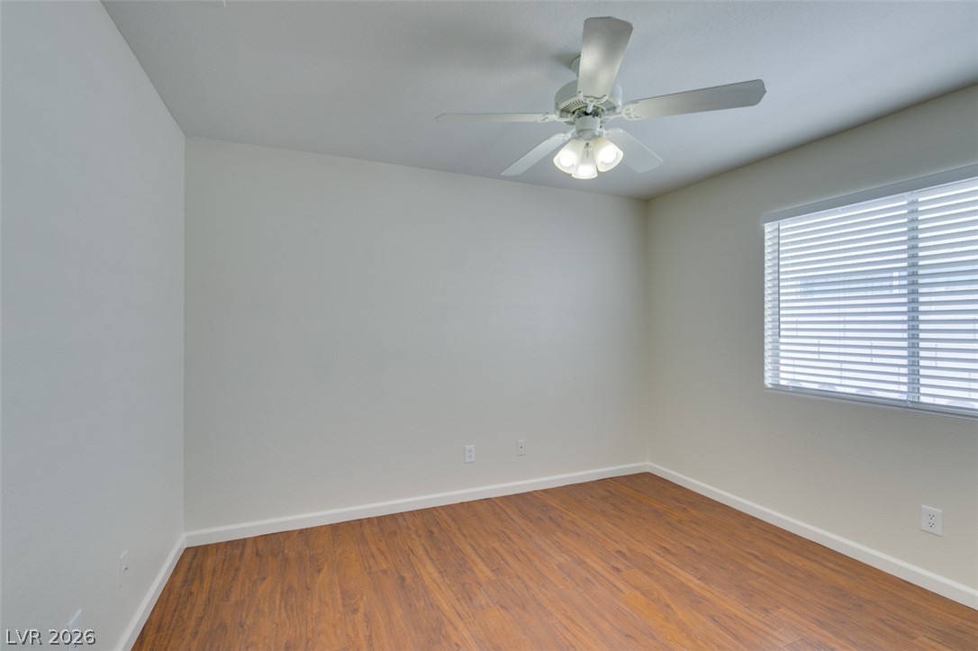 307 Cavalla Street Henderson, NV 89074 - Photo 31 of 44 A well-lit bedroom features durable hardwood flooring and a functional ceiling fan with lighting.