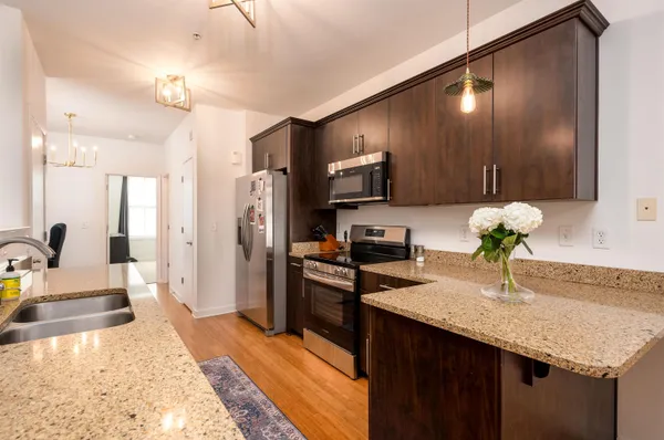 a large kitchen with stainless steel appliances granite countertop a refrigerator and a sink