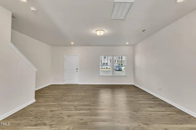 a view of empty room with wooden floor