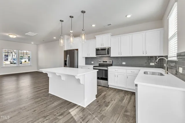 a kitchen with stove a sink and a refrigerator