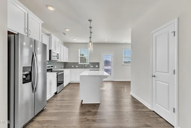 a kitchen with stainless steel appliances a refrigerator sink and cabinets