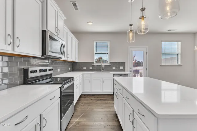 a kitchen with stainless steel appliances granite countertop a sink a stove oven a counter space and cabinets