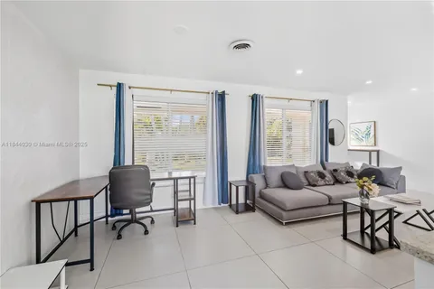 a living room with furniture and a floor to ceiling window