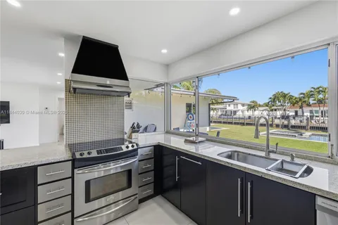 a kitchen with stainless steel appliances a sink stove and cabinets