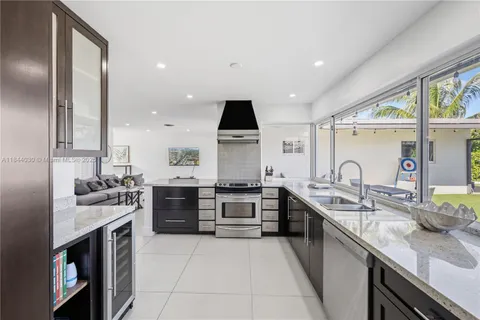 a large kitchen with stainless steel appliances granite countertop a stove sink and cabinets