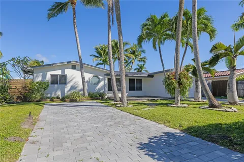 a front view of a house with garden and trees