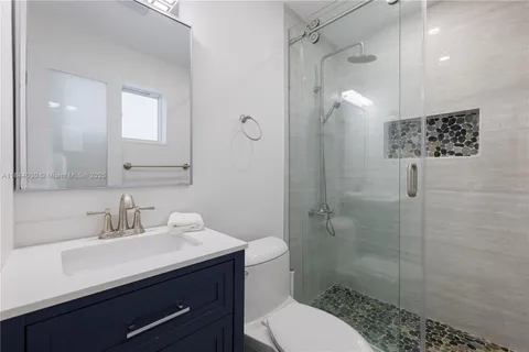 a bathroom with a sink a toilet and shower