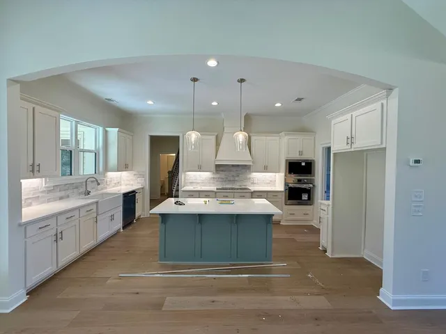 a large kitchen with kitchen island a sink stainless steel appliances and cabinets