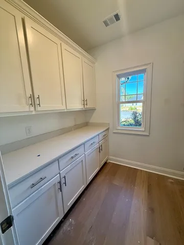 a view of a kitchen with wooden floor and electronic appliances
