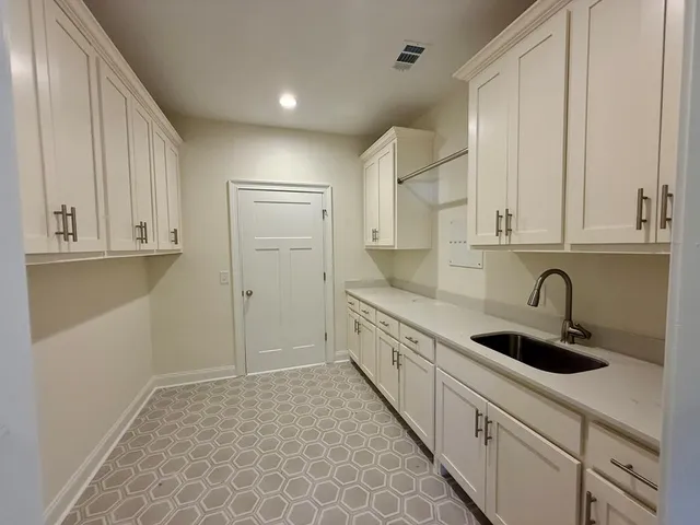 a kitchen with stainless steel appliances granite countertop a sink and cabinets with wooden floor