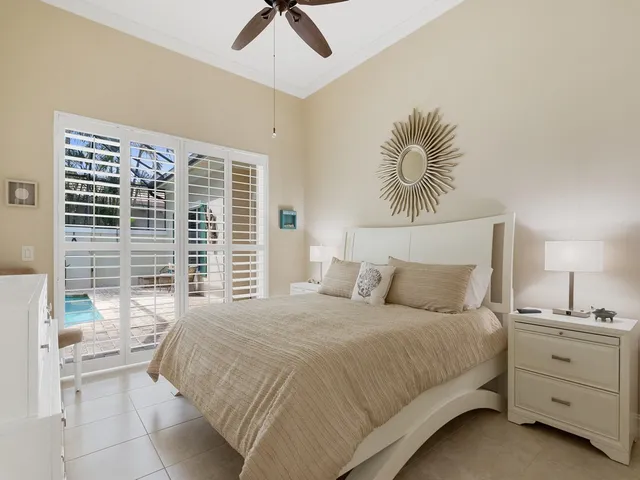 a bedroom with a large bed and a chandelier fan