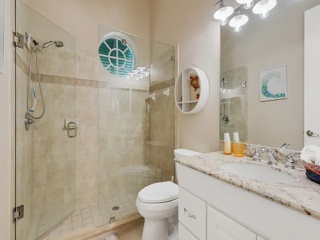 a bathroom with a granite countertop sink toilet and shower