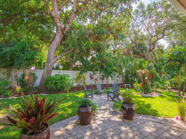 a view of a chair and table in backyard of the house