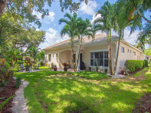 a backyard of a house with lots of green space and fountain