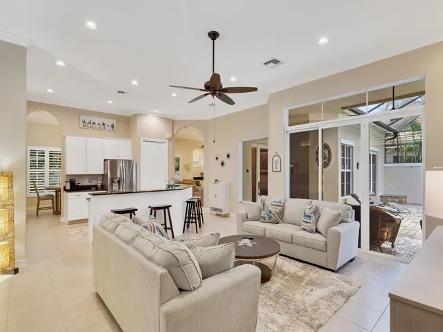 a living room with furniture kitchen view and a wooden floor