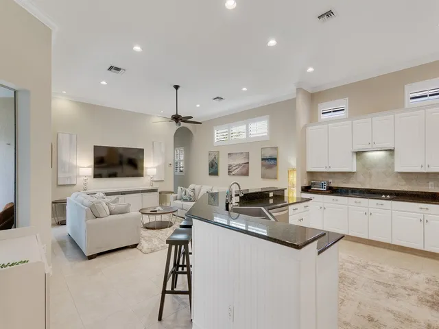 a kitchen with stainless steel appliances granite countertop a sink and a couch
