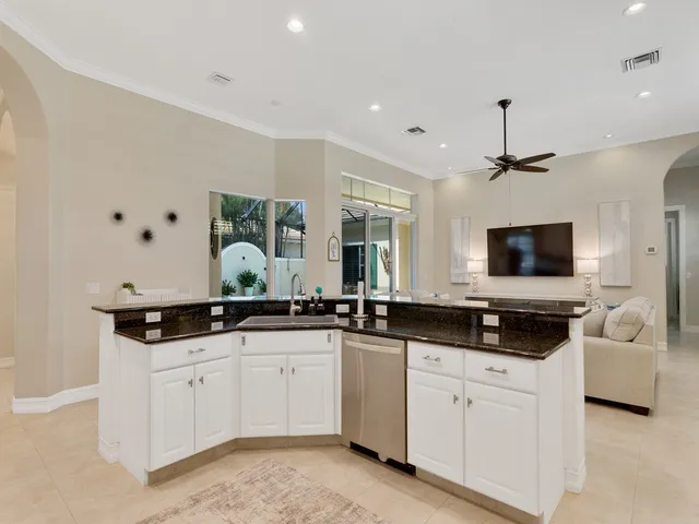 a large white kitchen with a sink and cabinets