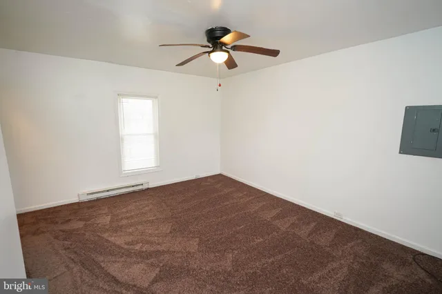 an empty room with ceiling fan and window