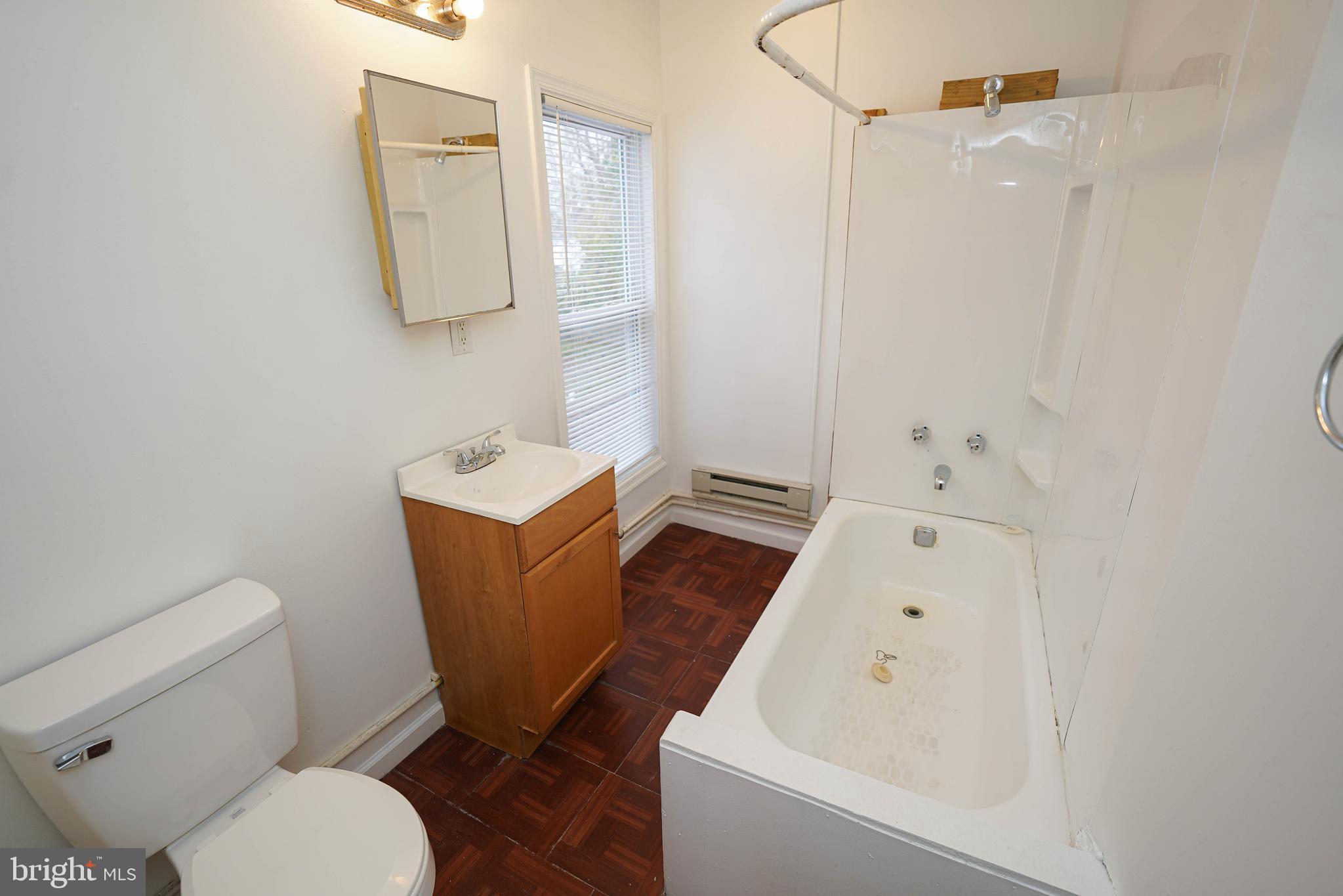417 Walnut Street, Unit 2 Pocomoke City, MD 21851 - Photo 28 of 33 a bathroom with a toilet sink and mirror