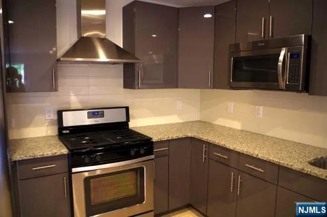 a kitchen with granite countertop a stove and a sink