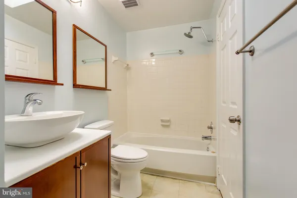 a bathroom with a sink a toilet a mirror and shower
